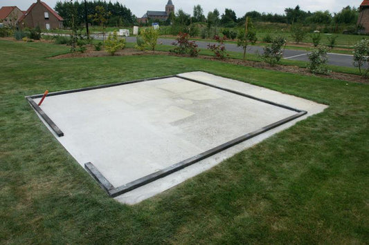 Préparation du sol avec dalle béton pour installer un abri de jardin en bois